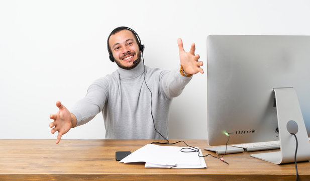 Telemarketer Colombian man presenting and inviting to come with hand