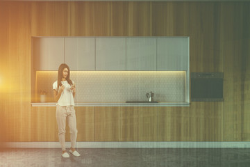 Woman with phone in wooden kitchen