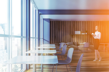 Blonde woman in gray and wooden cafe with sofas