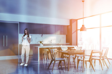 Woman with phone in kitchen with bar