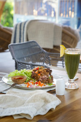 Rice and beef meat served with chips, salad and green detox smoothie. Casual dining restaurant food.