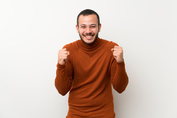 Colombian man with turtleneck sweater celebrating a victory in winner position