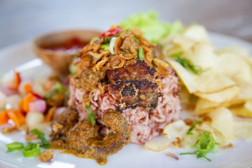 Rice and beef meat served with chips and green salad, casual dining restaurant food