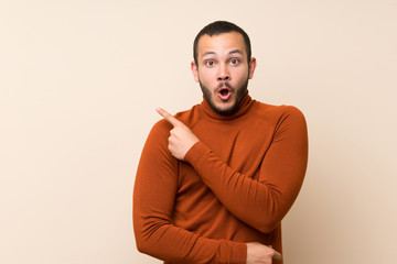 Colombian man with turtleneck sweater surprised and pointing side