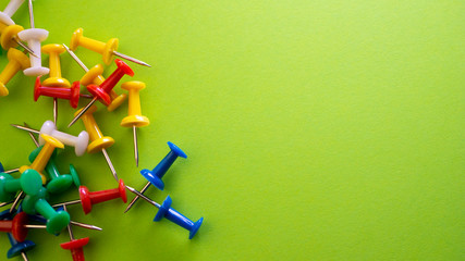 Color push pins on green background for copyspace