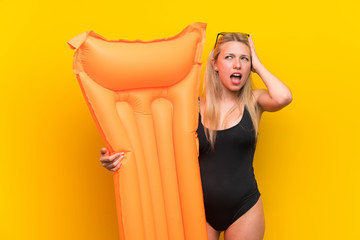 Young woman in swimsuit over yellow background unhappy and frustrated with something. Negative...