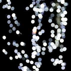 Unfocused abstract white bokeh on black background. defocused and blurred many round light