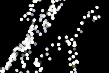 Unfocused abstract white bokeh on black background. defocused and blurred many round light
