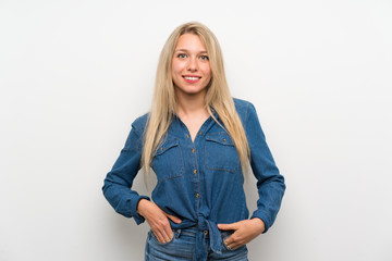 Young blonde woman over isolated white wall laughing