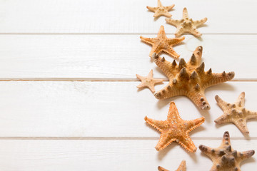Fototapeta na wymiar Summertime wooden table with starfish and seashells on a white background top view. Copy space background, summer concept
