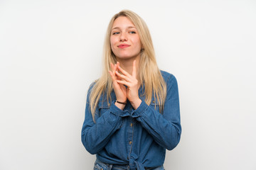 Young blonde woman over isolated white wall scheming something
