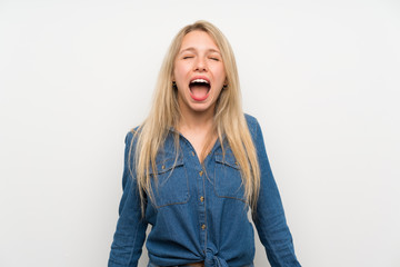 Young blonde woman over isolated white wall shouting to the front with mouth wide open