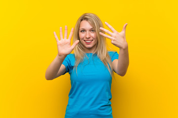 Young blonde woman over isolated yellow background counting nine with fingers