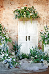 Naklejka premium Flower decoration. Wedding decor. Flower interior composition in the studio. Spring photo zone. White doors. 