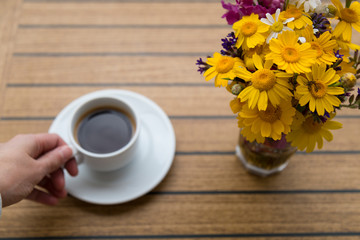 a cup of coffee with flowers on the table in the balcony. enjoy holiday time at the hotel or house