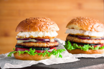 tasty chicken burgers with fried egg cucumber tomato mozzarella cheese lettuce