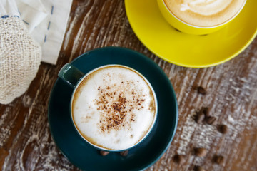 A cup of hot fresh coffee with rich foam on the wooden table