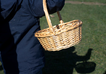 Closeup rear view of little boy carrying easter basket hunting, kid having fun on Easter egg hunts at the farm in the sunny day, Easter hunt concept
