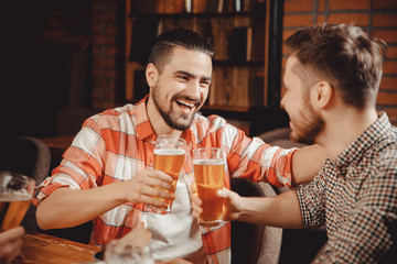 Group of friends enjoying drink pub, tells funny story