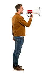 Blonde handsome man shouting through a megaphone