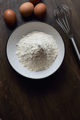  flour in a plate on a wooden background
