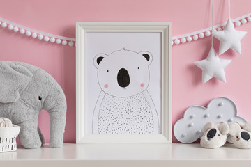 Modern scandinavian newborn baby room with mock up poster frame, plush elephant, cloud, shoes and children accessories. Cozy interior with pink walls. Haniging cotton garland and stars. Template