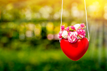 Obraz premium Stone rose flower in the pot with red heart-shaped on bokeh nature background in the public park, For love and Valentine's Day concept.