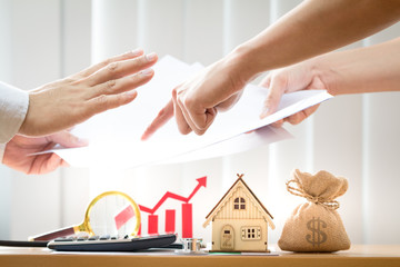 Businessmen are agreeing and home and red bar graph with growing value  in the office, Investment...