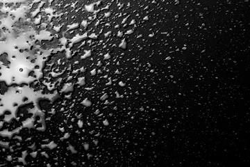Spilled milk puddle with droplets isolated on black background and texture, top view