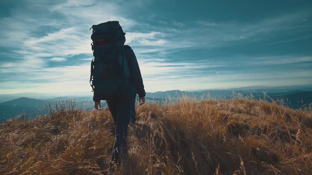 The couple walking on the mountain on a sunny background