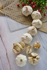 Garlic on a sack cloth againts a marble background, top view.