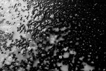 Spilled milk puddle with droplets isolated on black background and texture, top view