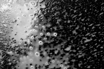 Spilled milk puddle with droplets isolated on black background and texture, top view
