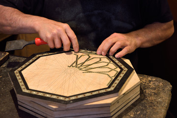 Craftsman working on handmade inlaid platter in a Alhambra shop Granada