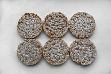six round rice cakes on gray plastic trat. rice cake, puffed rice on the gray background. rice galettes. Rice Waffle. Diet rice cakes..