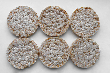 six round rice cakes on gray plastic trat. rice cake, puffed rice on the gray background. rice galettes. Rice Waffle. Diet rice cakes..