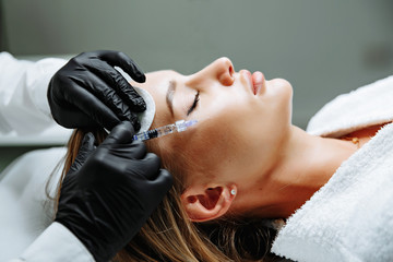 Young woman receiving plastic surgery injection on her face - 269743743