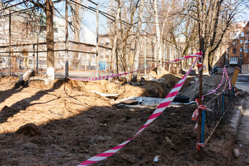 Red and white tape protects the construction site. Dredged land on the construction site.