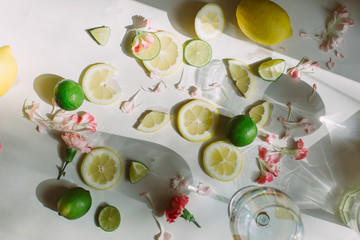 Slices of lemon and lime lying on the table with a sunlight through the glass