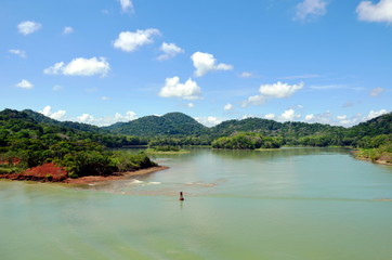 Green landscape of the Panama Canal, view from transiting container ship.