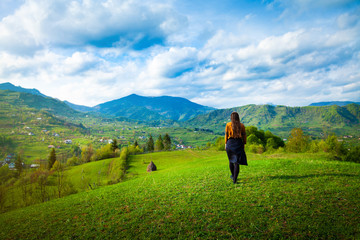 Girl walking through peaceful hills small village landscape area