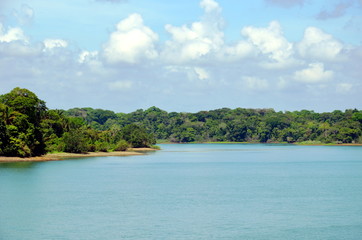 Green landscape of the Panama Canal, view from transiting container ship.