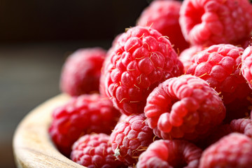 Fresh raspberry in a wooden plate. Close up of fresh organic sweet berries.