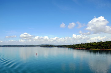 Green landscape of the Panama Canal, view from transiting container ship.