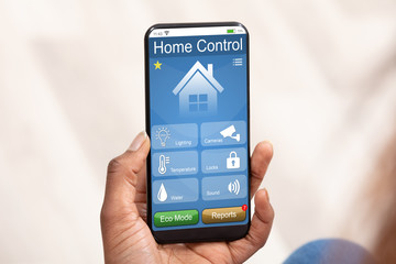 Person Using Home Control System On Mobile Phone