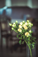 A bouquet of beautiful roses flowers on blurred home background of dining room kitchen