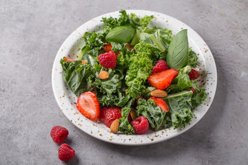 Vitamin salad with kale salad, basil, strawberry, raspberry and nuts