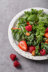 Vitamin salad with kale salad, basil, strawberry, raspberry and nuts