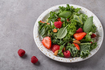 Vitamin salad with kale salad, basil, strawberry, raspberry and nuts