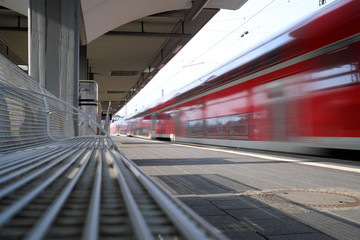 Menschenleerer Bahnsteig und ausfahrender Nahverkehrszug - Stockfoto